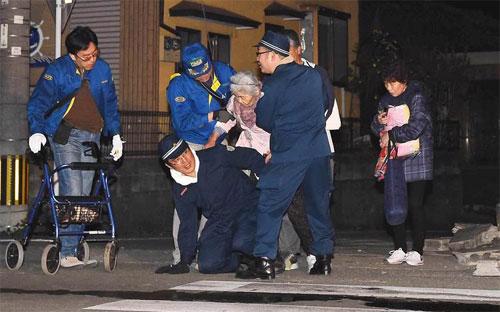 Các nhân viên cứu hộ đang trợ giúp một người già sau trận động đất ngày 14/4 ở Kumamoto, Nhật Bản - Ảnh: Bloomberg/Getty.<br>