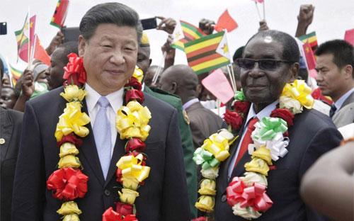 Chủ tịch Trung Quốc Tập Cận Bình (trái) và Tổng thống Zimbabwe Robert Mugabe trong chuyến thăm Zimbabwe của ông Tập tháng 11/2015 - Ảnh: EPA.<br>