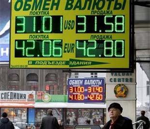 Một người đàn ông ngước nhìn bảng tỷ giá Euro/USD, tại một điểm đổi ngoại tệ ở Moskva (Nga) - Ảnh: AP.