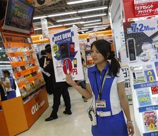 Một cô gái đứng giới thiệu sản phẩm điện thoại di động, tại một cửa hàng điện tử ở Tokyo, Nhật, ngày 17/6 - Ảnh: Reuters.