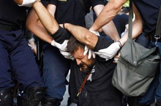 Một người dân Hy Lạp bị cảnh sát bắt giữ vì biểu tình phản đối các chính sách thắt lưng buộc bụng - Ảnh: Reuters.