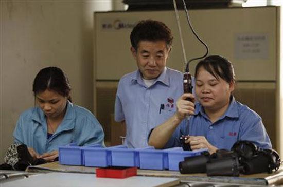 Ông Masayuki Aida, kỹ sư Nhật, đang giám sát công nhân Trung Quốc làm việc trong một nhà máy ở Đông Quản - Ảnh: Reuters.