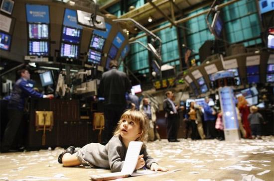 Bé Gabriella Liloia nằm trên sàn của Sở Giao dịch Chứng khoán New York (NYSE) ngày 27/11/2009. Đây cũng là ngày duy nhất trong năm, NYSE cho phép trẻ em được vào "thăm" sàn chứng khoán - Ảnh: Reuters.