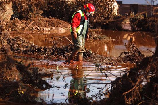 Bùn đỏ là chất thải độc hại có thể làm phỏng da - Ảnh: Reuters.