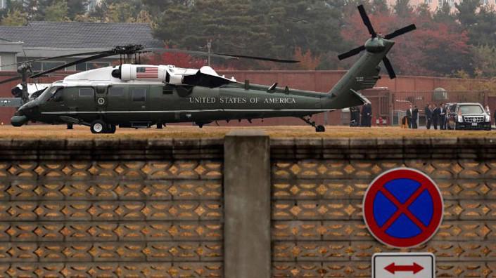Các quan chức cấp cao Nhà Trắng đang bàn bạc bên ngoài trong khi Tổng thống Donald Trump ngồi trong xe, sau khi chuyến thăm khu phi quân sự (DMZ) giữa hai miền bán đảo Triều Tiên sáng 8/11 không thể diễn ra vì sương mù - Ảnh: Reuters.