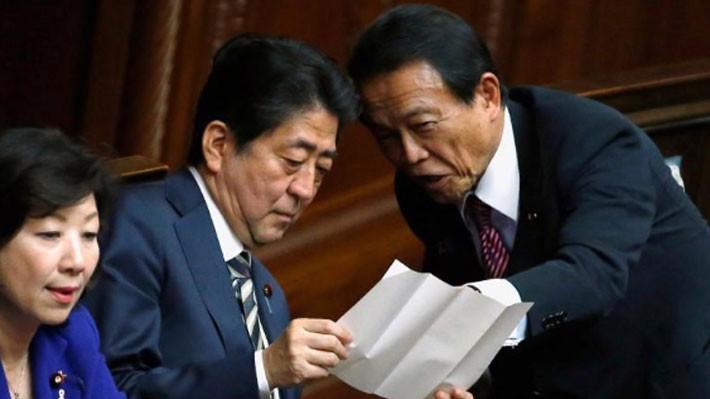Thủ tướng Nhật Bản Shinzo Abe (giữa) và Bộ trưởng Bộ tài chính Taro Aso (phải) - Ảnh: Reuters.