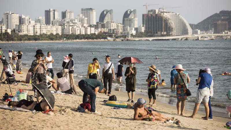 Du khách trên bãi biển Tam Á thuộc đảo Hải Nam, Trung Quốc - Ảnh: Bloomberg.