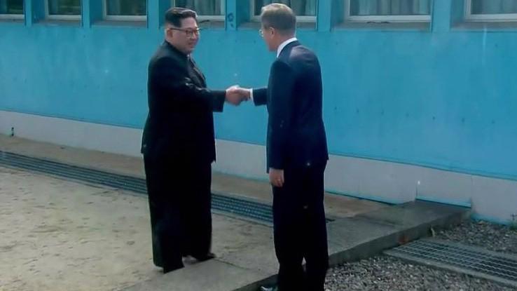 Nhà lãnh đạo Triều Tiên Kim Jong Un (trái) bắt tay Tổng thống Hàn Quốc Moon Jae-in tại giới tuyến quân sự giữa hai miền Triều Tiên sáng 27/4 - Ảnh: Bloomberg.