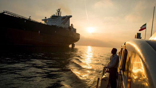 Một tàu hộ tống mang cờ Iran di chuyển cạnh con tàu chở dầu Devon trên vùng biển Bandar Abbas, hôm 23/3/2018 - Ảnh: Bloomberg/CNBC.