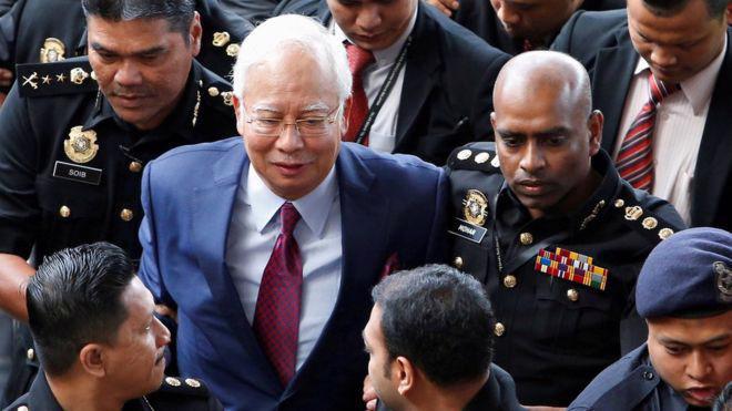 Cựu Thủ tướng Malaysia Najib Razak trong một lần bị cảnh sát áp giải - Ảnh: Reuters.
