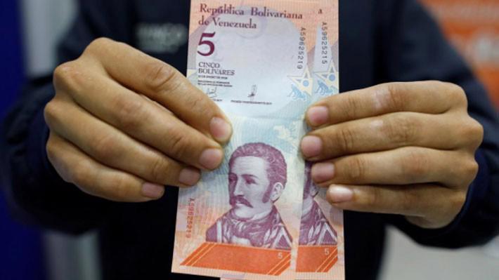 Đồng 5 Bolivar mới được rút ra từ một cây ATM ở Caracas, Venezuela, ngày 20/8 - Ảnh: Reuters.
