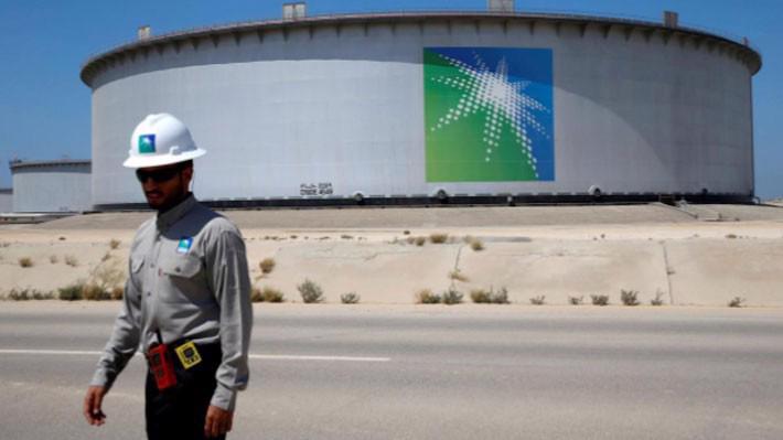 Một nhân viên của Saudi Aramco đi qua một bể chứa dầu tại nhà máy lọc dầu Ras Tanura của hãng này - Ảnh: Reuters.