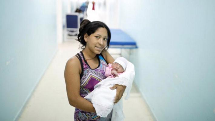 Một phụ nữ Venezuela bế đứa con mới sinh tại bệnh viện phụ sản ở thành phố Boa Vista thuộc bang Roraima của Brazil, ngày 21/8 - Ảnh: Reuters.