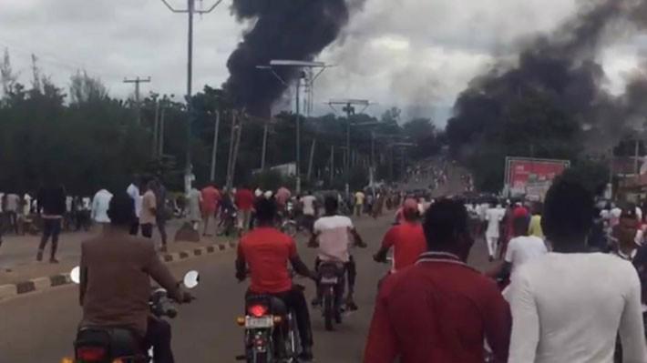 Người đi đường dừng lại để quan sát cột khói bốc lên từ đám cháy của vụ nổ xe chở xăng ở Nigergia ngày 10/9 - Ảnh: Twitter/Reuters.