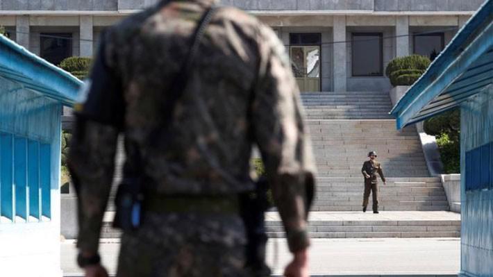 Một binh sỹ Hàn Quốc và một binh sỹ Triều Tiên đứng làm nhiệm vụ tại giới tuyến ở khu phi quân sự (DMZ) giữa hai miền - Ảnh: Reuters.