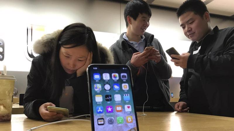 Khách hàng xem điện thoại iPhone trong một cửa hiệu Apple Store ở Bắc Kinh, Trung Quốc - Ảnh: AP.