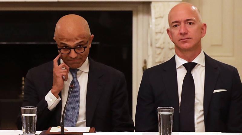Ông Satya Nadella (trái), CEO của Microsoft, và ông Jeff Bezos, CEO của Amazon.