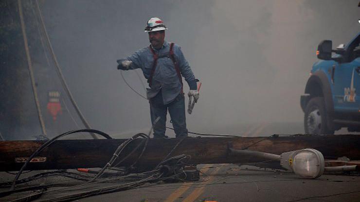 Một công nhân của PG&E đang xử lý một cột điện bị đổ trong đám cháy Camp Fire hôm 8/11/2018 - Ảnh: Getty/CNBC.