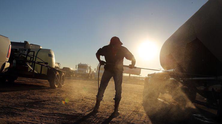 Một công nhân đang rửa những chiếc xe chở dầu tại một mỏ dầu ở Texas, Mỹ - Ảnh:Getty/CNBC.