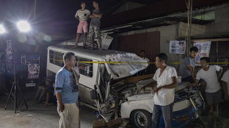 Người dân đứng xem lực lượng cứu hộ làm việc sau trận động đất ngày 22/4 ở Pampanga, Philippines - Ảnh: Getty/Bloomberg.
