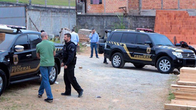 Lực lượng chức năng Brazil kiểm tra chiếc xe giả mạo xe cảnh sát mà toán cướp bỏ lại sau vụ cướp vàng ở Sao Paulo hôm 25/7 - Ảnh: AP/Bloomberg.