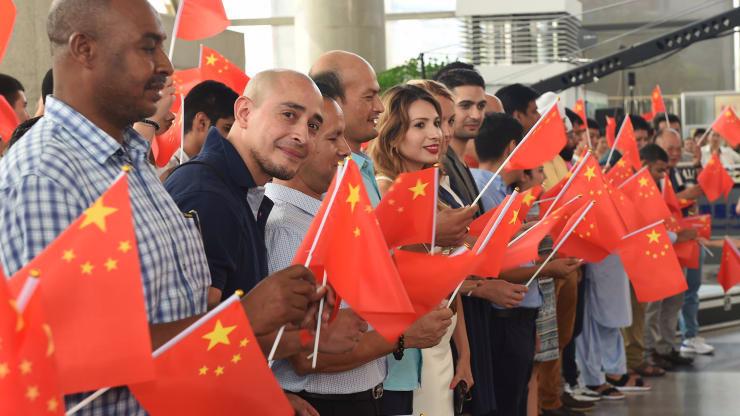 Người nước ngoài vẫy cờ Trung Quốc trong một sự kiện ở Yiwu, Triết Giang, Trung Quốc, tháng 8/2019 - Ảnh: Getty/CNBC.