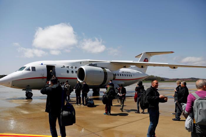 Hành khách chuẩn bị lên một máy bay của Air Koryo ở sân bay Bình Nhưỡng hôm 18/4 - Ảnh: Reuters.<br>