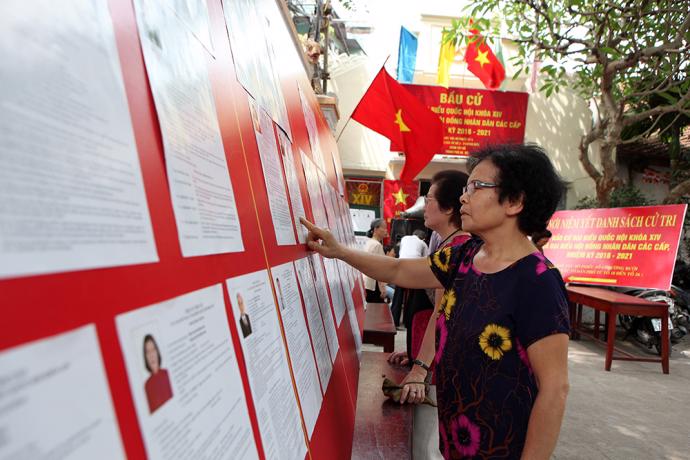 Người dân xem danh sách những người ứng cử tại đơn vị bầu cử số 3, phường Bưởi, quận Tây Hồ, Hà Nội - Ảnh: BGT.<br>