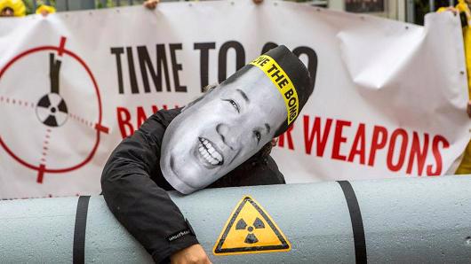 Một nhà hoạt động đeo mặt nạ hình nhà lãnh đạo Triều Tiên Kim Jong Un, ôm hình nộm bom hạt nhân, biểu tình trước đại sứ quán Triều Tiên ở Berlin, Đức, hôm 13/9 - Ảnh: Getty/CNBC.<br>