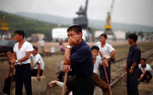 Công nhân nghỉ giải lao, chuẩn bị xem lễ khởi hành của một 
tàu du lịch đường dài tại đặc khu kinh tế Razon, Triều Tiên.