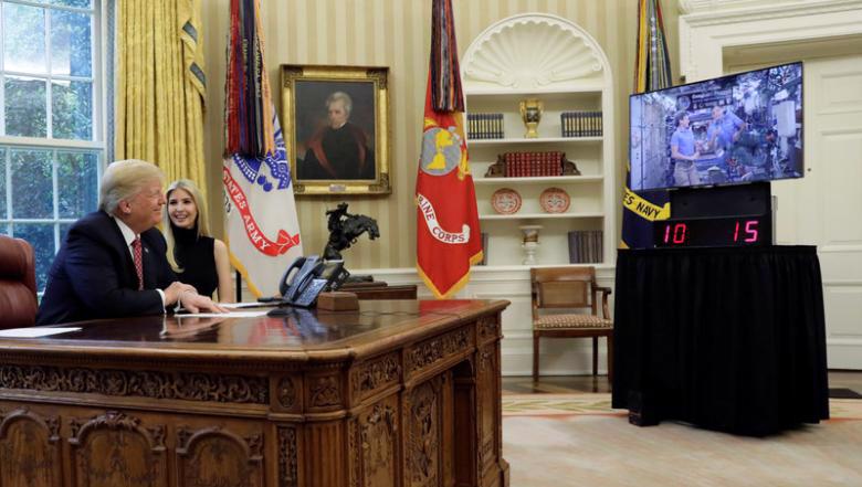 Tổng thống Mỹ Donald Trump trong cuộc gọi video từ Nhà Trắng với nhà du hành vũ trụ Peggy Whitson ở Trạm Vũ trụ Quốc tế (ISS) - Ảnh: Reuters.<br>