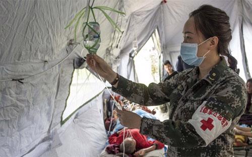 Một nhân viên cứu trợ người Trung Quốc đang giúp đỡ bệnh nhân ở Nepal - Ảnh: Tân Hoa Xã/SCMP.<br>