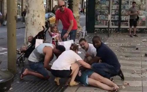 Một phụ nữ là nạn nhân vụ tấn công ở Barcelona ngày 17/8 đang được hỗ trợ - Ảnh: Reuters.<br>