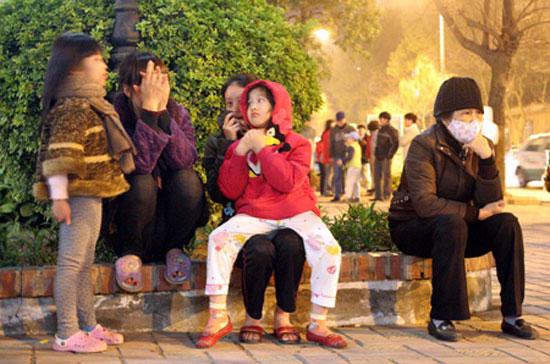 Người dân ở các cao ốc tại Hà Nội "sơ tán" xuống đường khi dư chấn xảy ra - Ảnh: Dân Trí. 