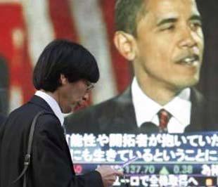 Một khách bộ hành tại Tokyo (Nhật Bản) đi ngang qua bảng điện tử đang chạy tin ông Obama đã đắc cử Tổng thống Mỹ, ngày 5/11/2008 - Ảnh: Reuters.