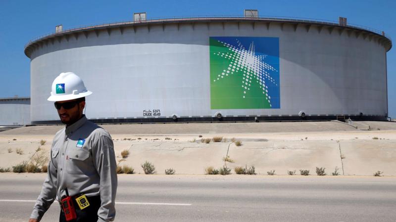 Một công nhân đi qua một bể chứa dầu tại nhà máy lọc dầu Ras Tanura của Saudi Arabia - Ảnh: Reuters/CNBC.