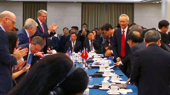 Bức ảnh đăng trên tài khoản Twitter của tờ Wall Street Journal cho thấy Phó thủ tướng Trung Quốc Lưu Hạc (đứng bên phải, cà vạt đỏ) ghé vào phòng đàm phán - Ảnh: Twitter.