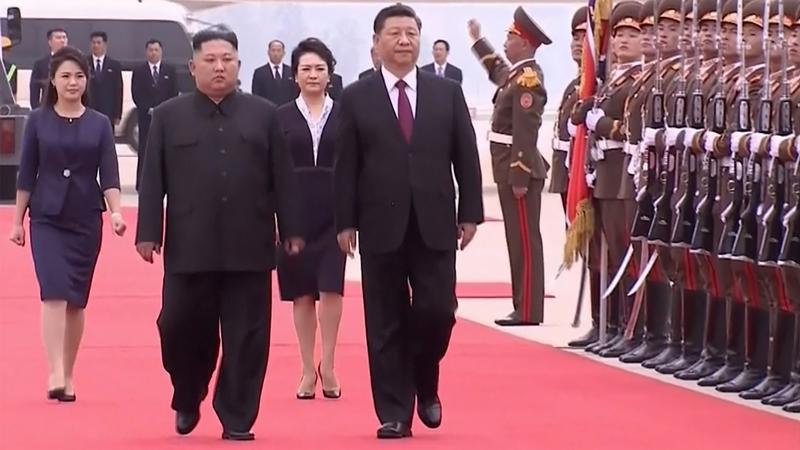 Nhà lãnh đạo Triều Tiên Kim Jong Un (trái) đón Chủ tịch Trung Quốc Tập Cận Bình sang thăm ngày 20/6 - Ảnh: AP/Bloomberg.