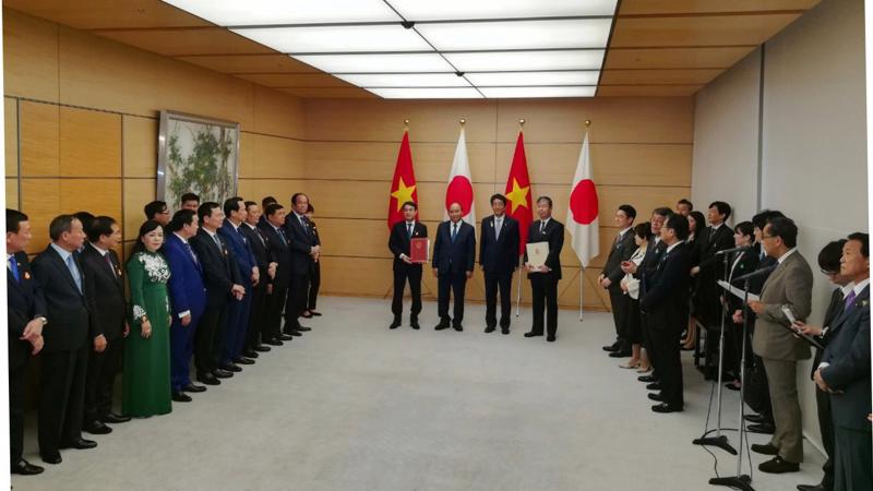 Ông Nghiêm Xuân Thành - Chủ tịch HĐQT Vietcombank (bên trái) và ông Kazuhiko Amakawa - Tổng Giám đốc điều hành JBIC (bên phải) thực hiện nghi thức trang trọng tại Lễ trao văn kiện trước sự chứng kiến của Thủ tướng Chính phủ Nguyễn Xuân Phúc và Thủ tướng Nhật Bản Shinzo Abe.