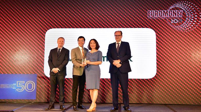 Đại diện Vietcombank, bà Nguyễn Thị Kim Oanh - Phó Tổng giám đốc (thứ 2 từ phải sang) và ông Nguyễn Tiến Đạt - Phó Trưởng phòng Kế hoạch TSC (thứ 2 từ trái sang) nhận giải thưởng “Ngân hàng tốt nhất Việt Nam” năm 2019 do tạp chí Euromoney trao tặng.