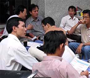 Các nhà đầu tư ngồi tràn ra vỉa hè đường Nguyễn Công Trứ - con đường tập trung nhiều sàn giao dịch tại Tp.HCM - để bàn luận, nghiên cứu thông tin chứng khoán - Ảnh: TT.