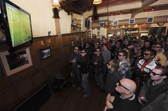 Người hâm mộ đang theo dõi trận cầu giữa Arsenal và Manchester, được truyền hình trực tiếp bằng công nghệ 3D, hôm 31/1/2010 - Ảnh: Reuters.