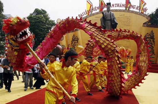 Múa rồng trong lễ khai mạc 10 ngày Đại lễ kỷ niệm 1.000 năm Thăng Long - Hà Nội, phía trước tượng đài vua Lý Thái Tổ - Ảnh: Reuters.