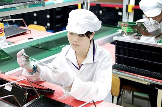 Một nữ công nhân Trung Quốc đang kiểm tra chất lượng bảng mạch trong nhà máy của Foxconn ở thành phố Thâm Quyến - Ảnh: BLB. 