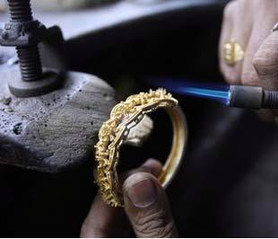Một thợ kim hoàn Ấn Độ đang chế tác đồ trang sức bằng vàng. Giá vàng thế giới đêm qua trải qua một phiên sụt giảm mạnh nhất trong vòng 6 tuần trở lại đây - Ảnh: AFP.