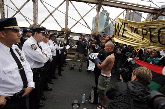 Cảnh sát Mỹ và người biểu tình đối mặt nhau trên cầu Brooklyn hôm 2/10 - Ảnh: Reuters.