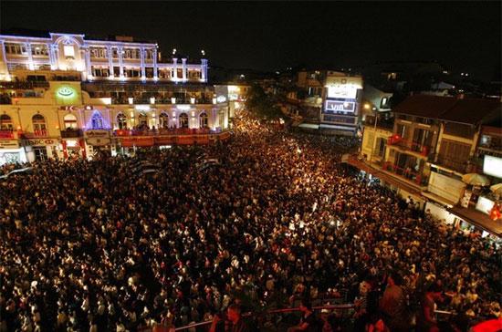 Dòng người đổ ra đường tại Hà Nội xem bắn pháo hoa chào mừng 35 năm thống nhất đất nước - Ảnh: Reuters.