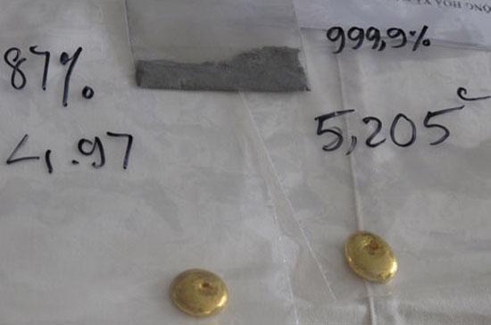 Túi bột màu xám phía trên ảnh là hỗn hợp kim loại với thành phần chính là Vonfram. Bên dưới là hai mẫu vàng pha kim loại nặng (trái) và vàng nguyên chất (phải), chúng không khác nhau về hình thức bên ngoài - Ảnh: VnExpress.