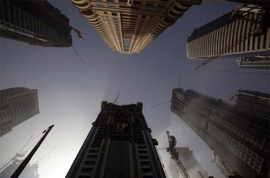 Nền kinh tế Dubai đã chịu tác động nặng nề từ khủng hoảng tài chính toàn cầu trong năm qua. Sự thắt chặt của các dòng vốn trong thời gian khủng hoảng đã đặt dấu chấm hết cho 6 năm phát triển bùng nổ của nước này, đồng thời đẩy thị trường bất động sản ở đây lao dốc không phanh - Ảnh: Reuters.