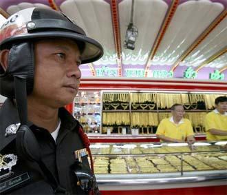 Cảnh sát đứng gác trong một cửa hàng vàng ở Bangkok, Thái Lan - Ảnh: AFP.